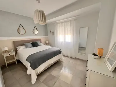 a bedroom with a large bed and a mirror at Victoria Centro 34 in Puerto Real