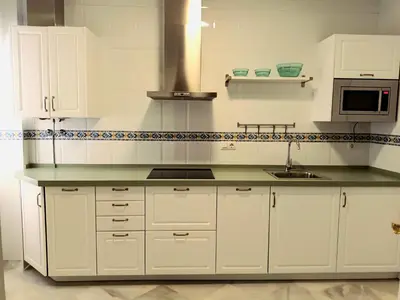 a kitchen with white cabinets and a sink at Casa de los Patios in Sanlúcar de Barrameda
