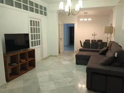 a living room with couches and a flat screen tv at Casa de los Patios in Sanlúcar de Barrameda