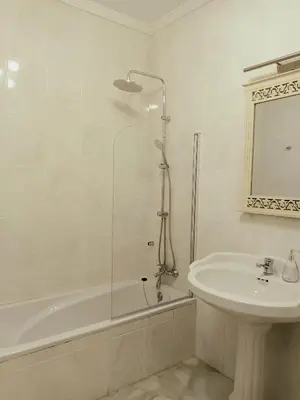 a white bathroom with a shower and a sink at Casa de los Patios in Sanlúcar de Barrameda