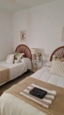 two beds in a room with a towel on the bed at Next to piletas 67 Sanlucar de Barrameda in Sanlúcar de Barrameda