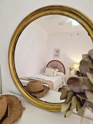 a bedroom with a bed and a mirror at Next to piletas 67 Sanlucar de Barrameda in Sanlúcar de Barrameda
