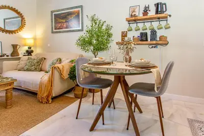 a living room with a table and a couch at Wehostcostaluz Le Petit Palace Catedral con parking gratuito in Jerez de la Frontera