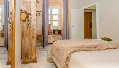 a bedroom with a bed and a large mirror at Wehostcostaluz Le Petit Palace Catedral con parking gratuito in Jerez de la Frontera