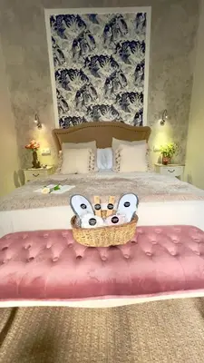 a bedroom with a bed with a pink bench at Wehostcostaluz Le Petit Palace Catedral con parking gratuito in Jerez de la Frontera