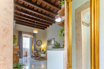a hallway of a home with a mirror at Wehostcostaluz Le Petit Palace Catedral con parking gratuito in Jerez de la Frontera