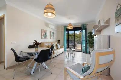 a living room with a table and chairs at Golden Sands Apartment - Chiclana de la frontera in Novo Sancti Petri