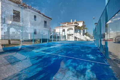 an empty tennis court in front of a building at Golden Sands Apartment - Chiclana de la frontera in Novo Sancti Petri
