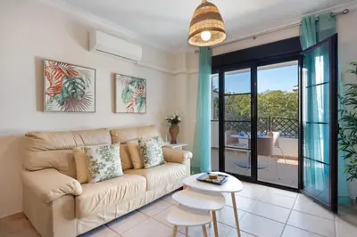 a living room with a couch and a table at Golden Sands Apartment - Chiclana de la frontera in Novo Sancti Petri