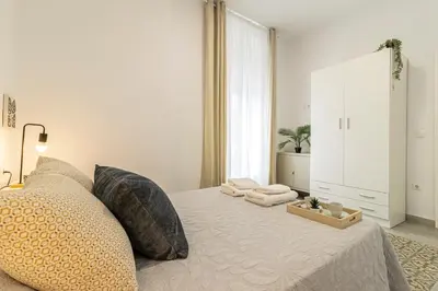 a bedroom with a bed with two pillows and a mirror at Apartamento Santa Clara 1 in Jerez de la Frontera