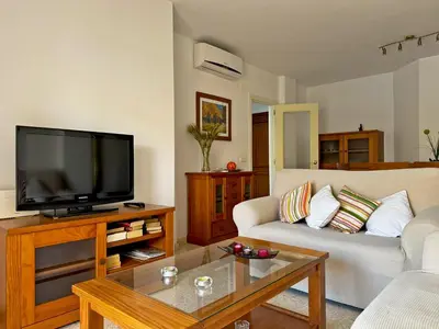 a living room with a couch and a tv at Apartamento Albatros - Ole Solutions in Sanlúcar de Barrameda