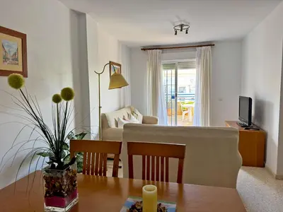 a living room with a table and a dining room at Apartamento Albatros - Ole Solutions in Sanlúcar de Barrameda