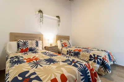 a bedroom with two beds with colorful blankets at Apartamento Santa Clara 3 in Jerez de la Frontera