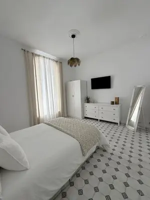 a white bedroom with a bed and a tv at Villa Palacio con Piscina Privada in Puerto Real