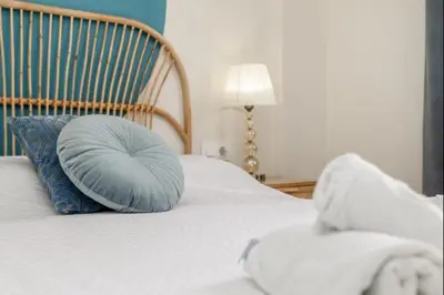a bed with a blue pillow on top of it at Agua Marina by Staycare in Rota