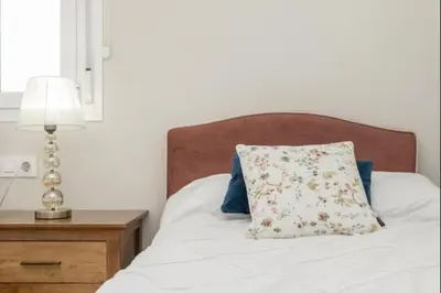 a bed with a pillow and a table with a lamp at Agua Marina by Staycare in Rota