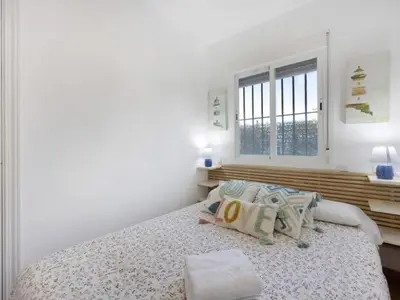 a white bedroom with a bed and a window at Arrecife Home by Staycare in Rota