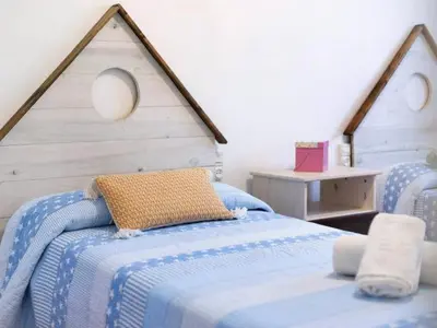 a bedroom with two beds with blue and white sheets at Arrecife Home by Staycare in Rota