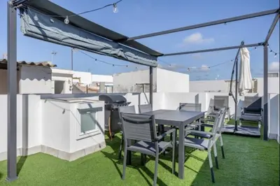 a patio with a table and chairs on a roof at Atico castelar by Staycare in Rota