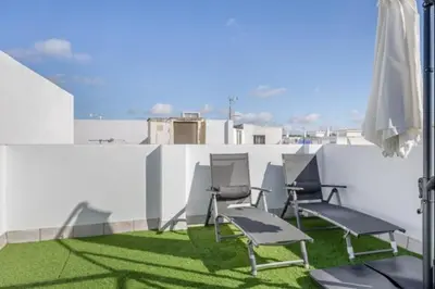 a group of chairs and an umbrella on a balcony at Atico castelar by Staycare in Rota