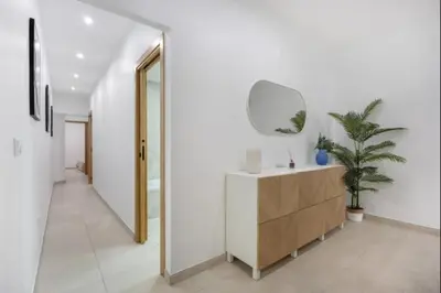 a white hallway with a dresser and a mirror at Atico castelar by Staycare in Rota