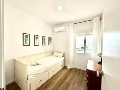 a white bedroom with a bed and a window at Brisa marina free parking by Staycare in Rota