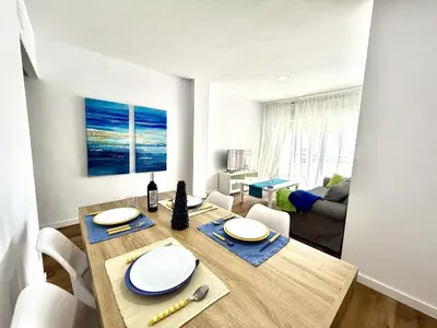 a dining room with a wooden table and chairs at Brisa marina free parking by Staycare in Rota