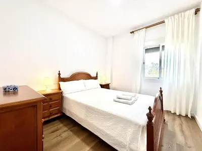 a white bedroom with a bed and a window at Brisa marina free parking by Staycare in Rota