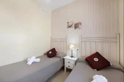 a bedroom with two beds and a night stand with two pillows at Budha Candor free parking by Staycare in Rota