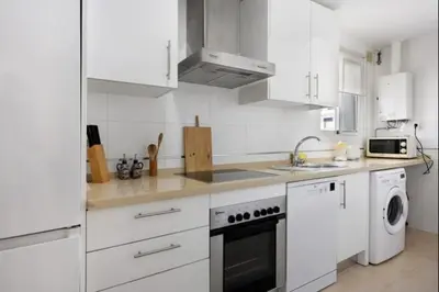 a white kitchen with a stove and a dishwasher at Budha Candor free parking by Staycare in Rota