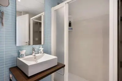 a bathroom with a white sink and a shower at Budha Candor free parking by Staycare in Rota