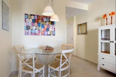 a dining room table with chairs and a painting on the wall at Budha Candor free parking by Staycare in Rota