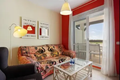 a living room with a couch and a glass table at Budha Candor free parking by Staycare in Rota