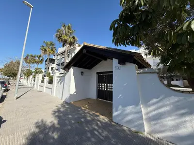 a white building with a gate on a street at Budha Candor free parking by Staycare in Rota