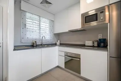a kitchen with white cabinets and a microwave at Dunas Candor free parking by Staycare in Rota