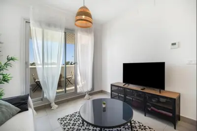 a living room with a flat screen tv and a table at Dunas Candor free parking by Staycare in Rota