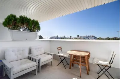 a patio with chairs and a table and a table and chairs at Dunas Candor free parking by Staycare in Rota