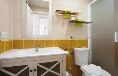a bathroom with a sink and a toilet and a mirror at V Centenario free parking by Staycare in Rota