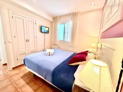 a bedroom with a bed with two towels on it at V Centenario free parking by Staycare in Rota
