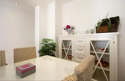 a white dining room with a table and chairs at V Centenario free parking by Staycare in Rota