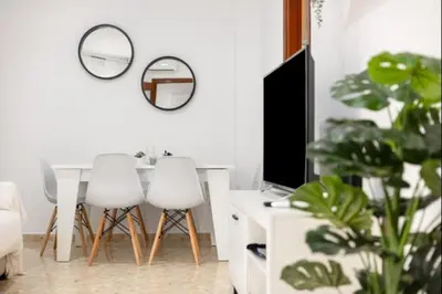 a living room with a table and chairs and a television at Girasoles Rota by Staycare in Rota