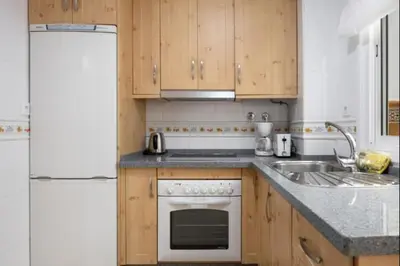 a kitchen with a white refrigerator and a sink at Girasoles Rota by Staycare in Rota