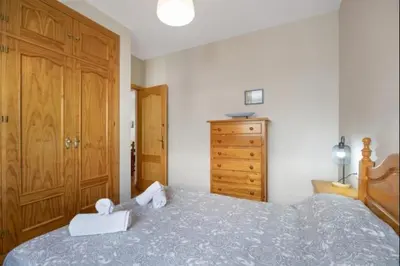 a bedroom with a bed and a wooden dresser at Esperanza free parking by Staycare in Rota
