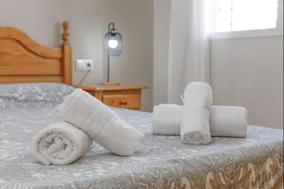 a bed with two rolls of towels on it at Esperanza free parking by Staycare in Rota
