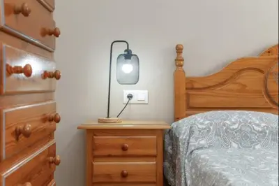 a bedroom with a bed and a lamp on a nightstand at Esperanza free parking by Staycare in Rota