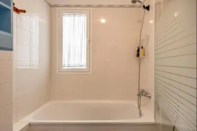 a white tub in a bathroom with a window at Paraíso del golf free parking by Staycare in Rota