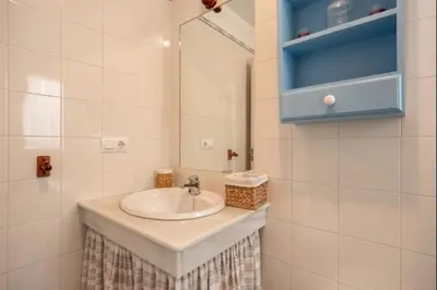 a white bathroom with a sink and a mirror at Paraíso del golf free parking by Staycare in Rota