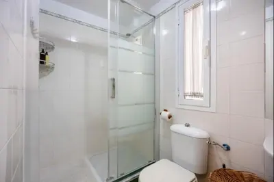 a white bathroom with a shower and a toilet at Paraíso del golf free parking by Staycare in Rota