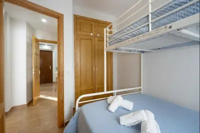 a bedroom with a blue bed with two bunk beds at Isaac Peral by Staycare in Rota