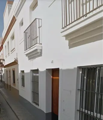 a white building with a wooden door on a street at Isaac Peral by Staycare in Rota